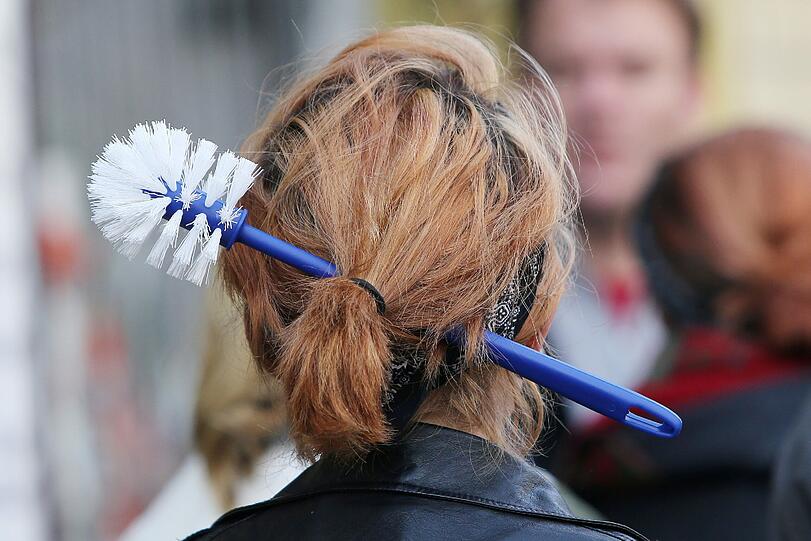 Hier gehört sie eigentlich nicht hin: Eine Frau trägt eine Klobürste als Haarschmuck. Johanniter-Mitarbeiter sollen Patienten mit so einem Reinigungsgerät erniedrigt haben.