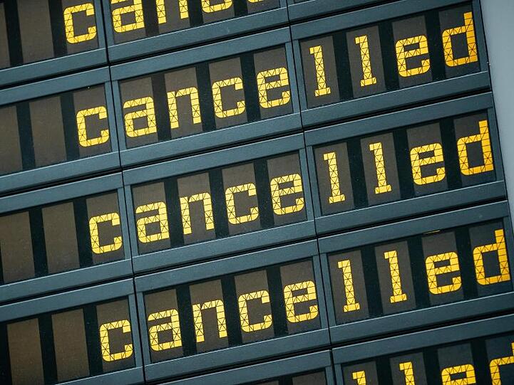 Die Anzeigetafel eines Flughafen zeigt viele Flüge als gestrichen an.