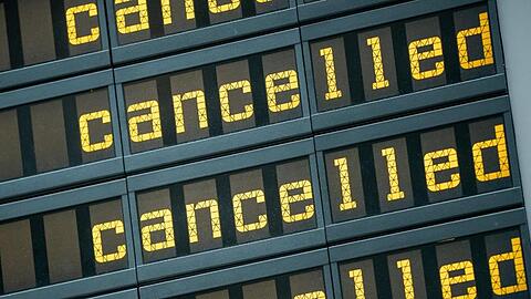 Die Anzeigetafel eines Flughafen zeigt viele Flüge als gestrichen an.