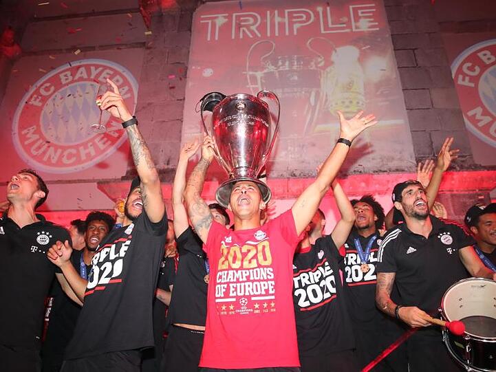 Thiago (M) und seine Teamkollegen feiern mit dem Pokal. Foto: Marco Donato/FC Bayern München AG/dpa