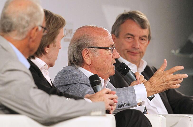 Franz Beckenbauer, Günter Netzer, der FIFA-Präsident Sepp Blatter und DFB-Präsident Wolfgang Niersbach (v.l.) sitzen im österreichischen Kitzbühel bei einer Podiumsdiskussion im Rahmen des «CAMP Beckenbauer».
