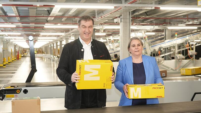 "Was ist da drin? Ist es was Schönes? Muss man's zurückschicken?", so Markus Söder, hier mit DHL-Konzernvorständin Nikola Hagleitner. "Was ist da drin? Ist es was Schönes? Muss man's zurückschicken?", so Markus Söder, hier mit DHL-Konzernvorständin Nikola Hagleitner.