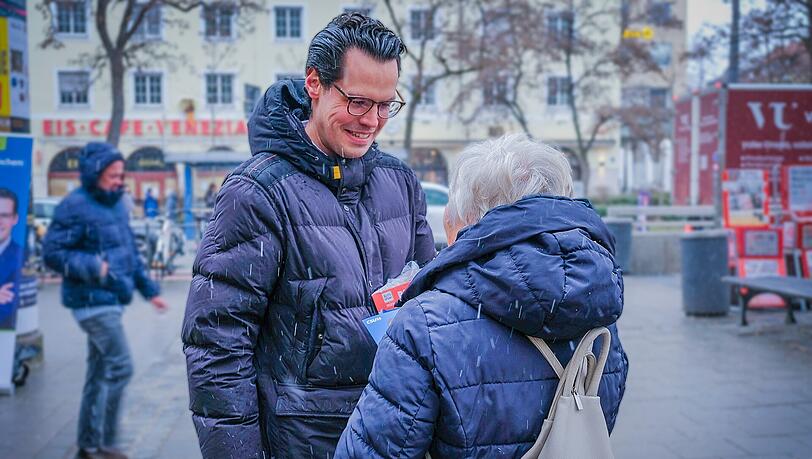 Gut gelaunt verteilt Kiefer am Wochenmarkt Flyer und Schokolade mit seinem Gesicht darauf.