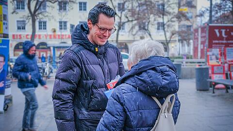 Gut gelaunt verteilt Kiefer am Wochenmarkt Flyer und Schokolade mit seinem Gesicht darauf.