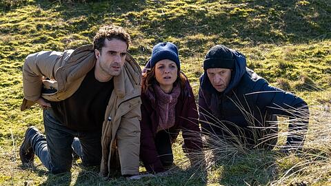 "Nord Nord Mord: Sievers und die f&uuml;nf Fragezeichen": Hinnerk Feldmann (Oliver Wnuk, l.), Ina Behrendsen (Julia Brendler, M.) und Carl Sievers (Peter Heinrich Brix) suchen Schutz hinter einem H&uuml;gel.