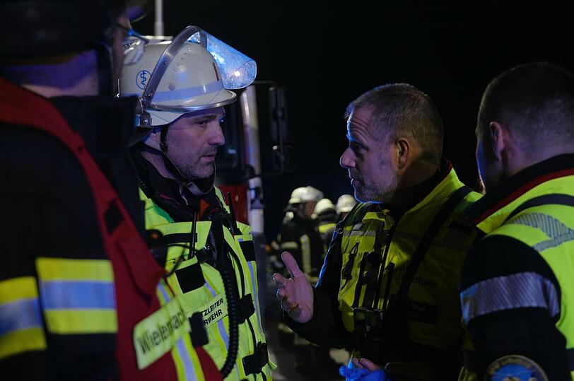 Der Murnauer Arzt Dr. Bender (links) bespricht sich mit einem Feuerwehrmann am Unfallort.