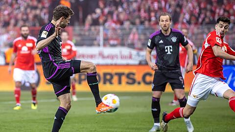 Thomas Müller (l) von Bayern München trifft den Ball zum 3:0.