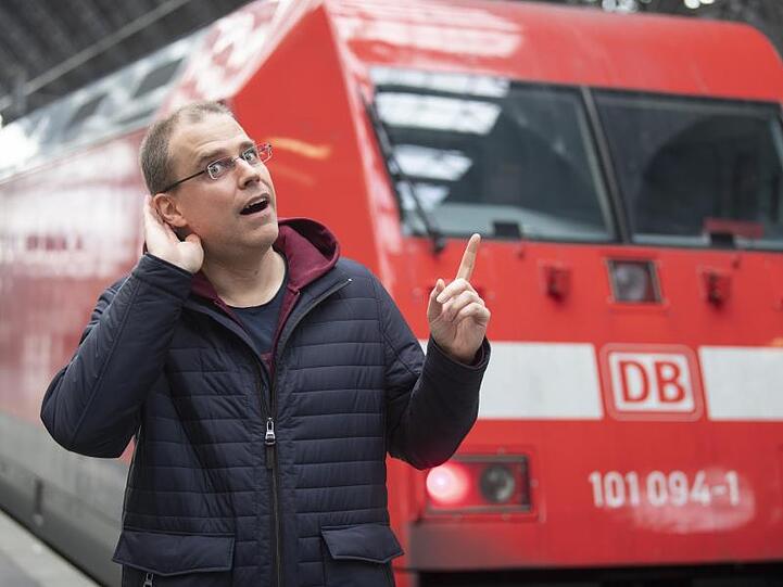 Der neue Bahnansager Heiko Grauel steht auf dem Hauptbahnhof Frankfurt vor einem Zug. Foto: Boris Roessler/dpa/Archivbild
