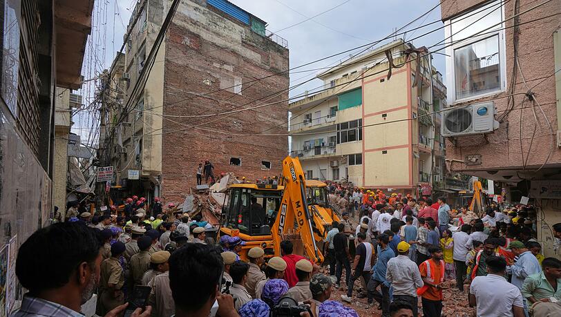 Rettungskr&auml;fte suchen in Neu-Delhi unter den Tr&uuml;mmern eines eingest&uuml;rzten Geb&auml;udes nach &Uuml;berlebenden.