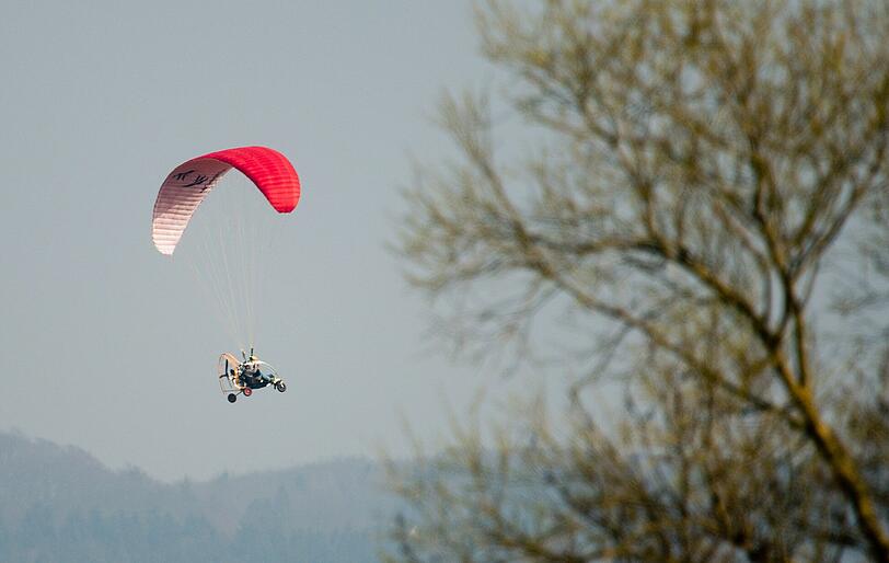 Ein Motorschirmpilot fliegt nutzt das Wetter für einen Ausflug. Aufgenommen bei Rinteln im Landkreis Schaumburg.