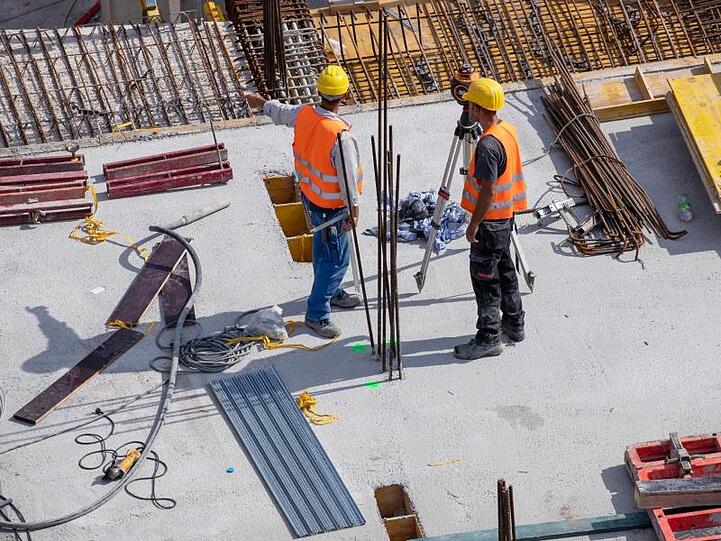 Arbeiter stehen auf einer Baustelle.