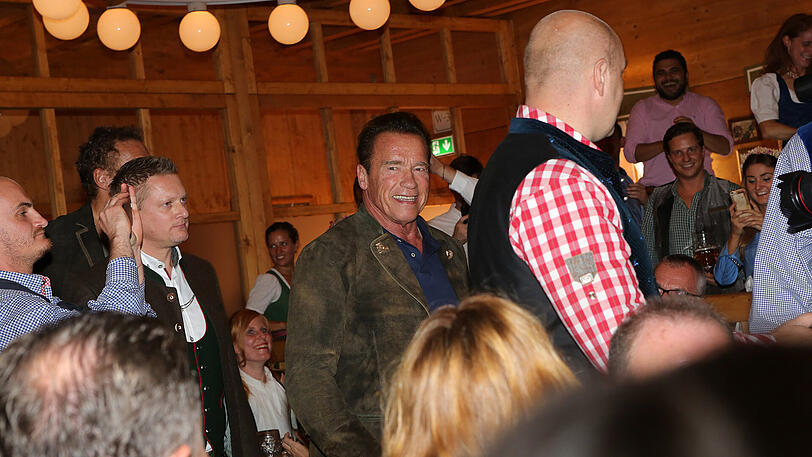 Erst eine kühle Maß, danach Dirigieren auf der Bühne: Die Bilder vom Schwarzenegger-Besuch im Schützen-Festzelt.