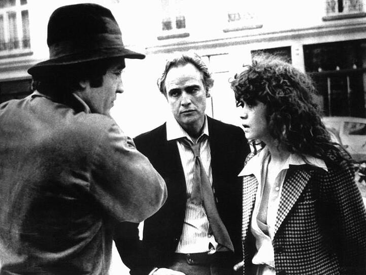 Regisseur Bernardo Bertolucci (l) im Gespräch mit seinen Hauptdarstellern Marlon Brando (M) und Maria Schneider bei den Dreharbeiten zu "Der letzte Tango in Paris" 1972.