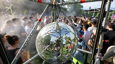 Besucherinnen und Besucher feiern 2024 auf einem Festival vor einer Techno B&uuml;hne. (Symbolbild)