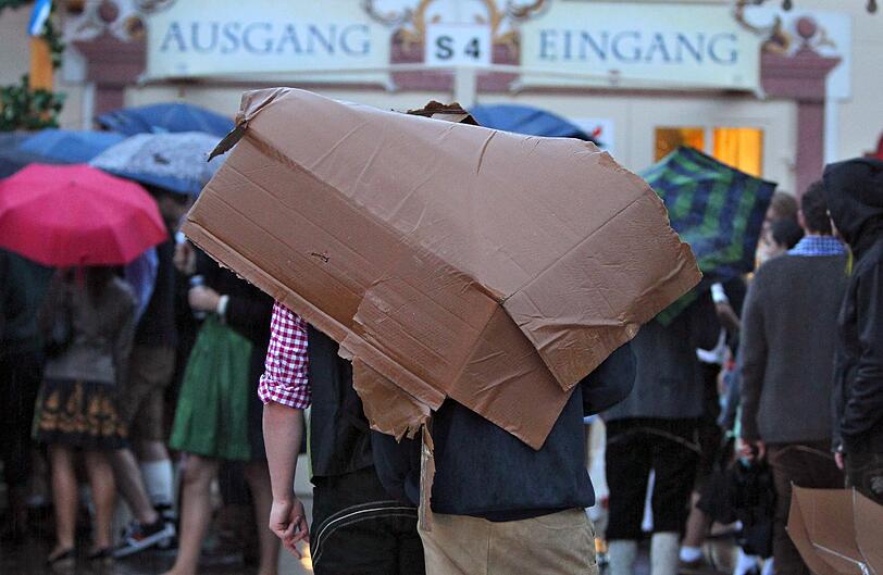 Trotz Sauwetter und Regen warten bereits viele Wiesngänger auf den Wiesnanstich. Der Kampf um den Platz im Bierzelt beginnt schon am frühen Morgen. Die ersten Bilder.