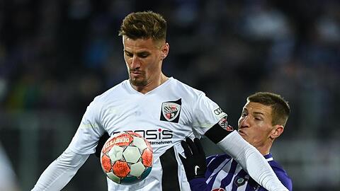 Aues Gaetan Bussmann (r) und Ingolstadts Stefan Kutschke kämpfen um den Ball.