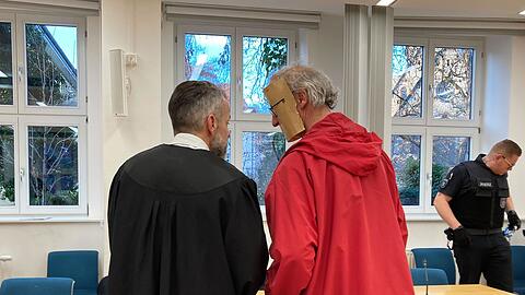 Der 53-jährige Angeklagte trug beim Betreten des Gerichtssaals eine augenscheinlich selbst gebastelte Papp-Maske, die sein Gesicht verdeckte.