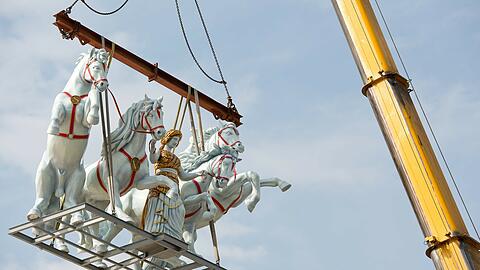 Die Bavaria zügelt vier wilde Schimmel auf dem Dach des Marstall-Zeltes.