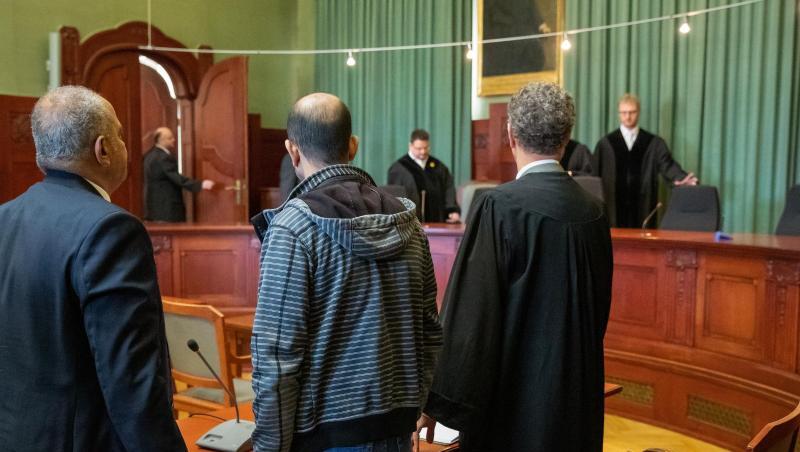 Ein wegen Mordes angeklagter Marokkaner (M) steht zu Verhandlungsbeginn im Sitzungssaal im Landgericht Bayreuth zwischen seinem Anwalt (r) und einem Übersetzer. Foto: Daniel Karmann Ein wegen Mordes angeklagter Marokkaner (M) steht zu Verhandlungsbeginn im Sitzungssaal im Landgericht Bayreuth zwischen seinem Anwalt (r) und einem Übersetzer. Foto: Daniel Karmann