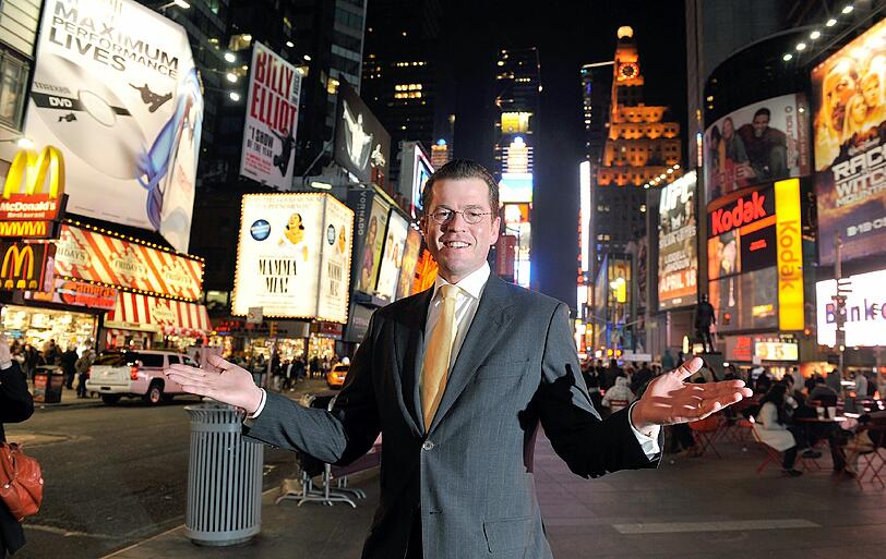Damals ein Medienliebling: Karl-Theodor zu Guttenberg mit ausgebreiteten Armen auf dem Times Square in New York. Foto: Gero Breloer/Archiv