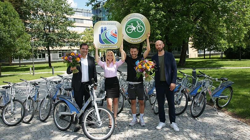 Ingo Wortmann (links) und Florian Zimmermann (rechts) von der MVG mit Susanne Weinzierl (100.000-ste Kundin) und Anselm Appel (1.000.000-ste Ausleihe)