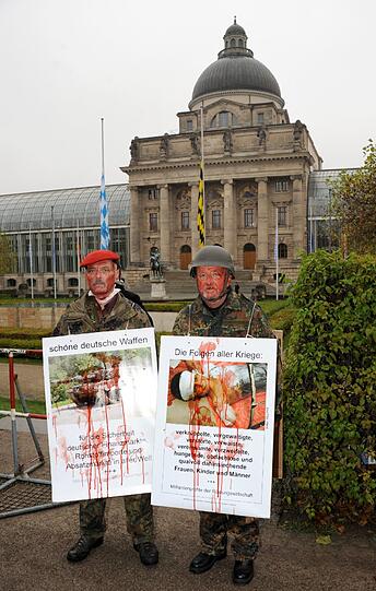 Mit Kunstblut verschmiert und in Bundeswehr-Uniformen demonstrierten zwei Männer um Aktionskünstler Wolfram R. Kastner gegen die Brutalität und Unnötigkeit des Krieges.