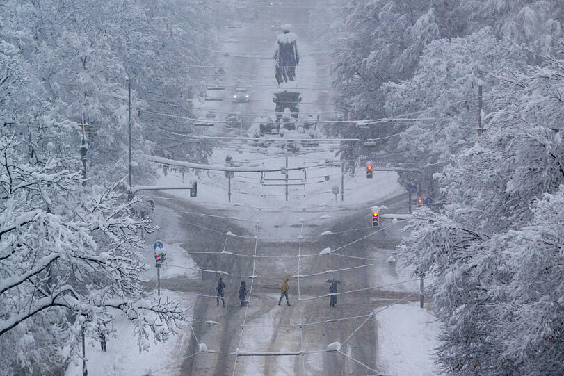 Passanten kreuzen die nur notdürftig geräumte Maximilianstraße um das Maxmonument.