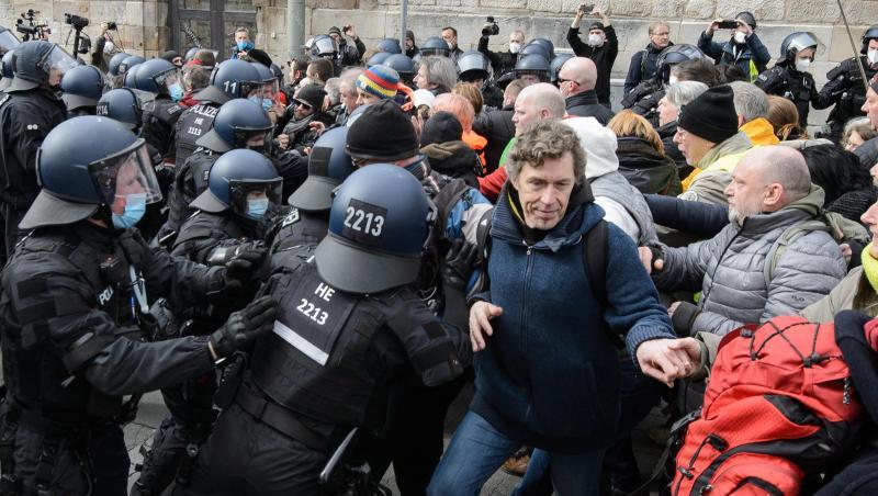 Einsatzkräfte der Polizei halten bei einer Kundgebung Teilnehmer zurück.