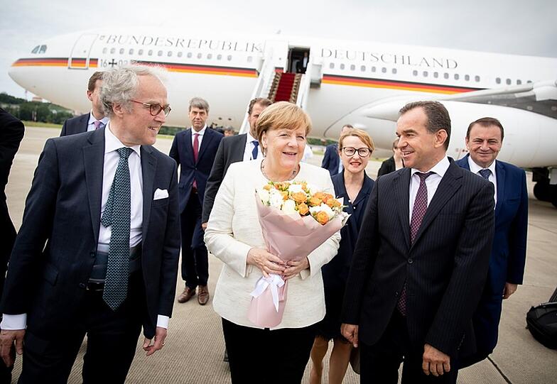 Bundeskanzlerin Angela Merkel (CDU) wird von dem Gouverneur der Region Krasnodar, Weniamin Iwanowitz Kodratjew (r) und dem deutschen Botschafter in Russland Rüdiger Freiherr von Fritsch (l), nach ihrer Ankunft am Internationalen Flughafen Sotschi begrüßt.