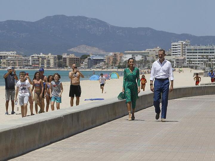 Ein ungewohntes Bild: Das spanische Königspaar spaziert am Strand entlang.