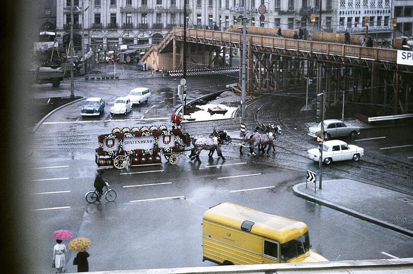 1968: Ein bisserl verloren wirkt die Spaten-Kutsche am Stachus, wo die 1965 errichtete Behelfsbrücke für Fußgänger zu sehen ist.