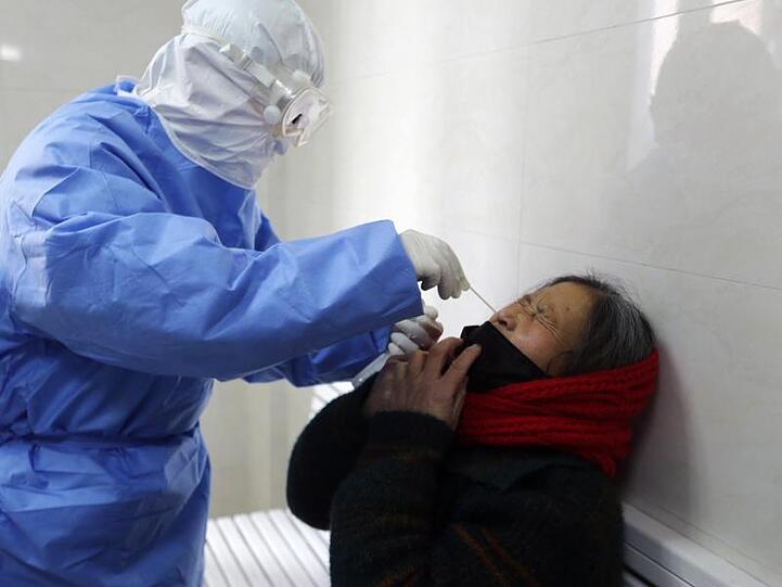 Test auf das Covid-19-Virus: Ein Arzt nimmt in einer Fieberklinik in der ostchinesischen Provinz Shandong einen Abstrich bei einer Frau.