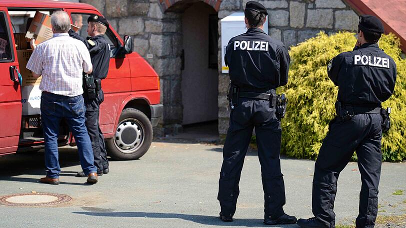 Polizeibeamte tragen im Juli 2014 Beweismittel aus dem beschlagnahmten ehemaligen Gasthof in Oberprex.