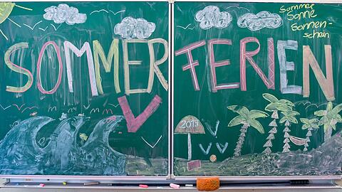 "Sommerferien" steht in großen, bunten Buchstaben an der Tafel einer Grundschule. Der erste Ferientag in Bayern wäre heuer Montag, der 27. Juli &ndash; wenn es nicht noch anders kommt.