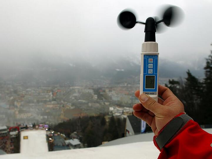 Ein Mann misst in Innsbruck die Windgeschwindigkeit.