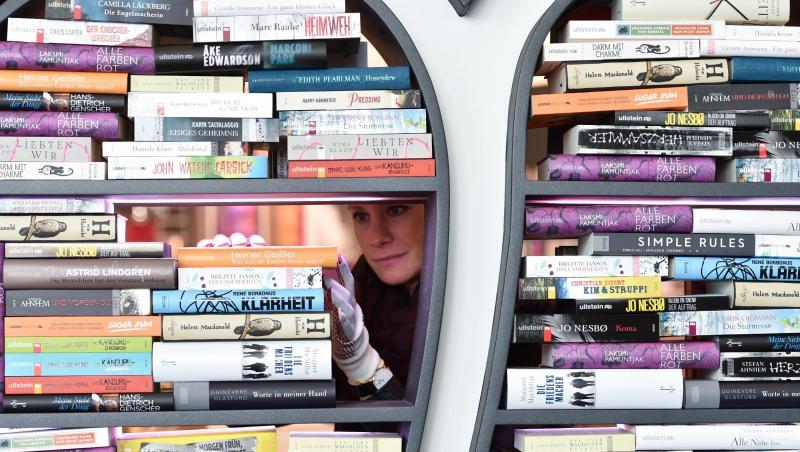 Eine Frau dekoriert ein Regal mit Büchern. Foto: Arne Dedert/dpa Eine Frau dekoriert ein Regal mit Büchern. Foto: Arne Dedert/dpa