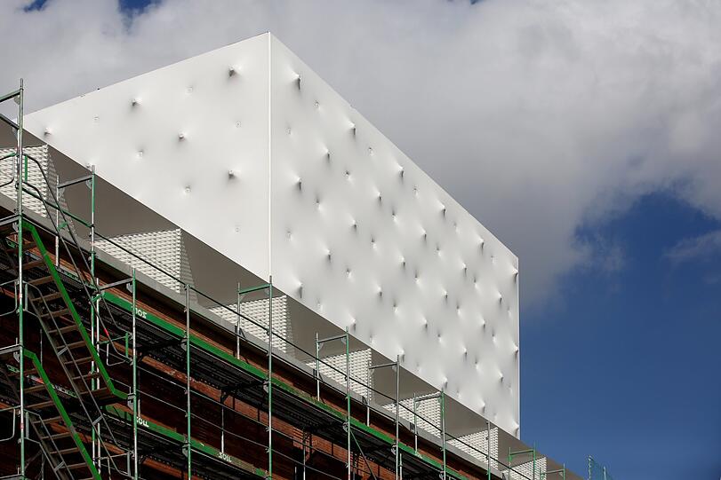Der weiße Dachaufbau des neuen Volkstheaters in weiß-blecherner Noppen-Optik - als hätte wer von innen wie von außen Gewehrsalven abgefeuert.