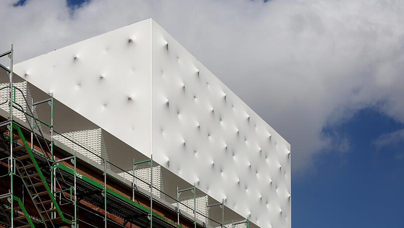 Der weiße Dachaufbau des neuen Volkstheaters in weiß-blecherner Noppen-Optik - als hätte wer von innen wie von außen Gewehrsalven abgefeuert. Der weiße Dachaufbau des neuen Volkstheaters in weiß-blecherner Noppen-Optik - als hätte wer von innen wie von außen Gewehrsalven abgefeuert.
