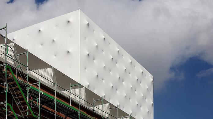 Der weiße Dachaufbau des neuen Volkstheaters in weiß-blecherner Noppen-Optik - als hätte wer von innen wie von außen Gewehrsalven abgefeuert.