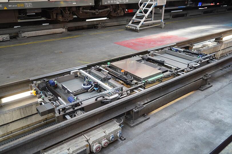 Der Roboter liegt flach in den Schienen und fährt mit einer Geschwindigkeit von einem halben Meter pro Sekunde unter die Bahn.