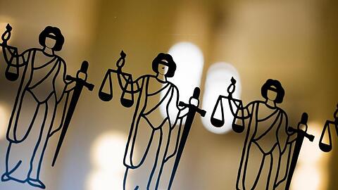 Justitia-Abbildungen sind an einer Scheibe zu sehen.