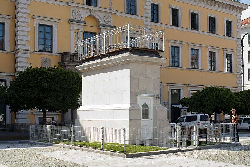 Das Projekt "Schöner Wohnen" des Münchner Künstlers Alexander Laner nutzt den "4th Plinth Munich" von Stephen Hall und Li Li Ren am Wittelsbacherplatz nicht in seiner Funktion als monumentalen Sockel, sondern eignet sich den gemauerten Hohlkörper als exklusive Immobilie an &ndash; ähnlich wie architektonische Umnutzungen bestehender Bauten zu Luxus-Immobilien.