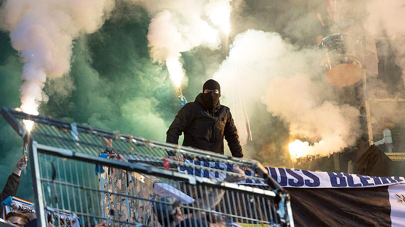Vermummt: Ein mutmaßlicher Ultra des TSV 1860 während des Pyro-Eklats in Augsburg.