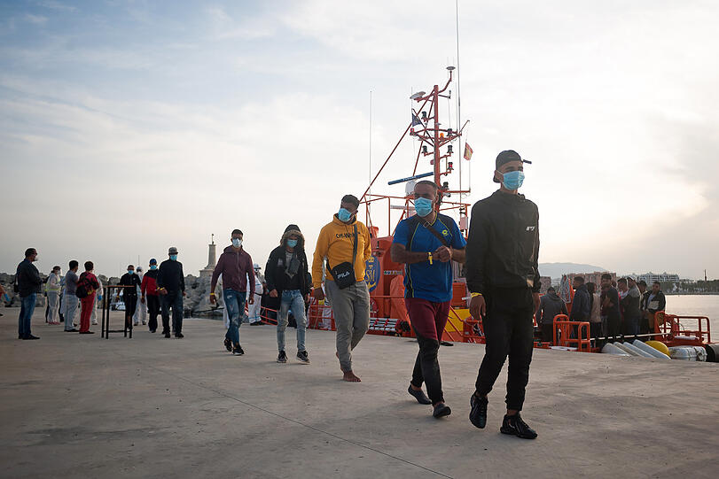 Eine Gruppe maghrebinischer Migranten wartet am Hafen im spanischen Malaga, nachdem sie von der Küstenwache im Mittelmeer gerettet wurde.