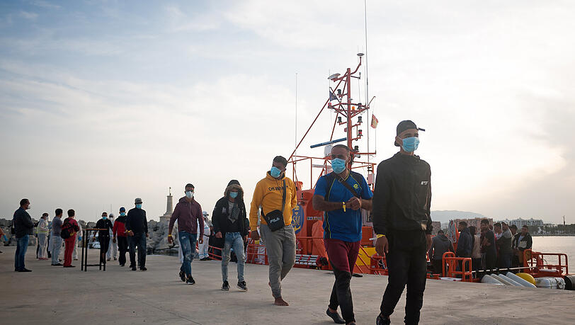 Eine Gruppe maghrebinischer Migranten wartet am Hafen im spanischen Malaga, nachdem sie von der Küstenwache im Mittelmeer gerettet wurde. Eine Gruppe maghrebinischer Migranten wartet am Hafen im spanischen Malaga, nachdem sie von der Küstenwache im Mittelmeer gerettet wurde.
