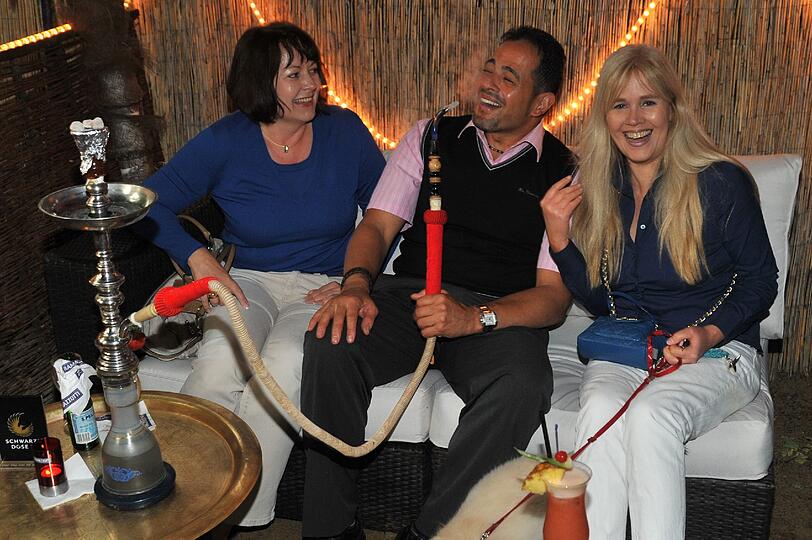 Ein ungewöhnliches Biergartenmotiv: Judith und Christiane wissen noch nicht, ob sie mit Chef Nabil Kotb Wasserpfeife rauchen sollen oder lieber erstmal nur schnuppern.