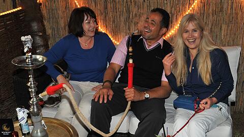 Ein ungewöhnliches Biergartenmotiv: Judith und Christiane wissen noch nicht, ob sie mit Chef Nabil Kotb Wasserpfeife rauchen sollen oder lieber erstmal nur schnuppern.