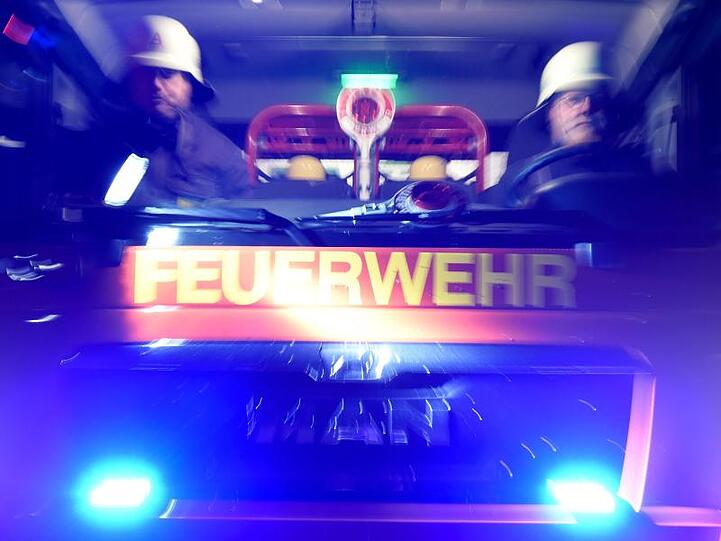 Feuerwehrmänner in einem Löschfahrzeug. Foto: Carsten Rehder/dpa/Archivbild