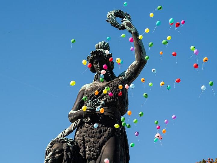Luftballons steigen beim Platzkonzert der Wiesenwirte über der Bavaria Statue auf.