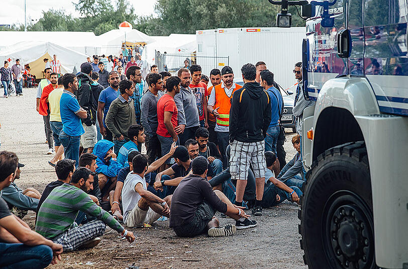 Flüchtlinge versammeln sich am Eingang des Aufnahmelagers an der Bremer Straße in Dresden.